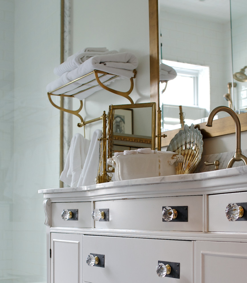 Foto på ett mellanstort vintage en-suite badrum, med ett undermonterad handfat, möbel-liknande, vita skåp, marmorbänkskiva, vit kakel, keramikplattor, en dusch i en alkov, en toalettstol med hel cisternkåpa, vita väggar och mörkt trägolv