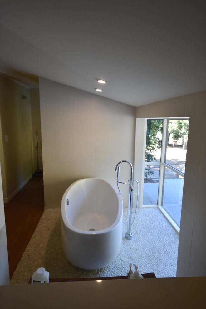 Inspiration pour une grande salle de bain principale minimaliste en bois brun avec un placard à porte plane, une baignoire indépendante, une douche d'angle, WC à poser, un carrelage beige, des carreaux de porcelaine, un mur beige, un sol en galet, un lavabo encastré, un plan de toilette en cuivre et un sol beige.