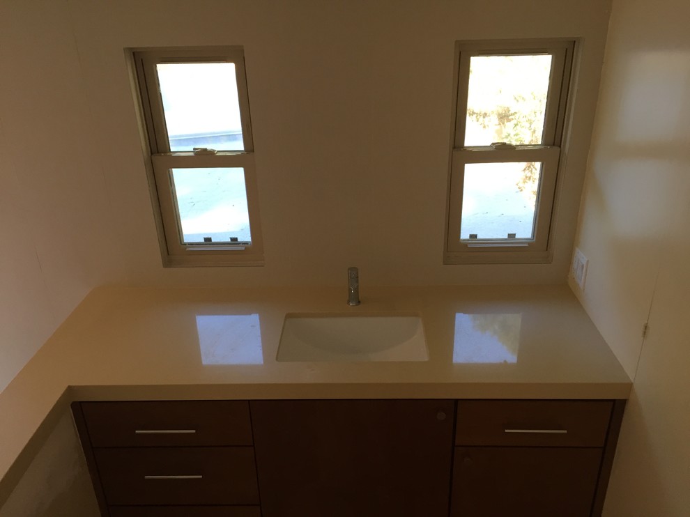 Bathroom - large modern master beige tile and porcelain tile pebble tile floor and beige floor bathroom idea in Los Angeles with flat-panel cabinets, medium tone wood cabinets, a one-piece toilet, beige walls, an undermount sink and copper countertops
