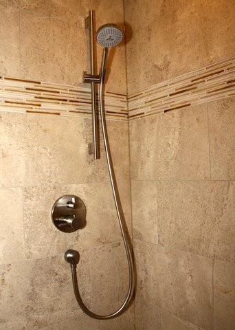 Cette photo montre une salle de bain chic en bois brun avec une douche d'angle, un carrelage beige, mosaïque et un mur beige.