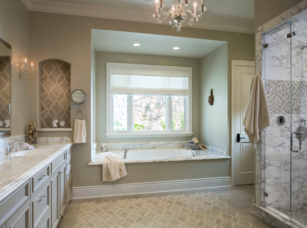 Klassisk inredning av ett stort en-suite badrum, med luckor med infälld panel, stenkakel, gröna väggar, kalkstensgolv, ett undermonterad handfat, marmorbänkskiva, en dusch i en alkov, grå kakel, vit kakel och ett badkar i en alkov