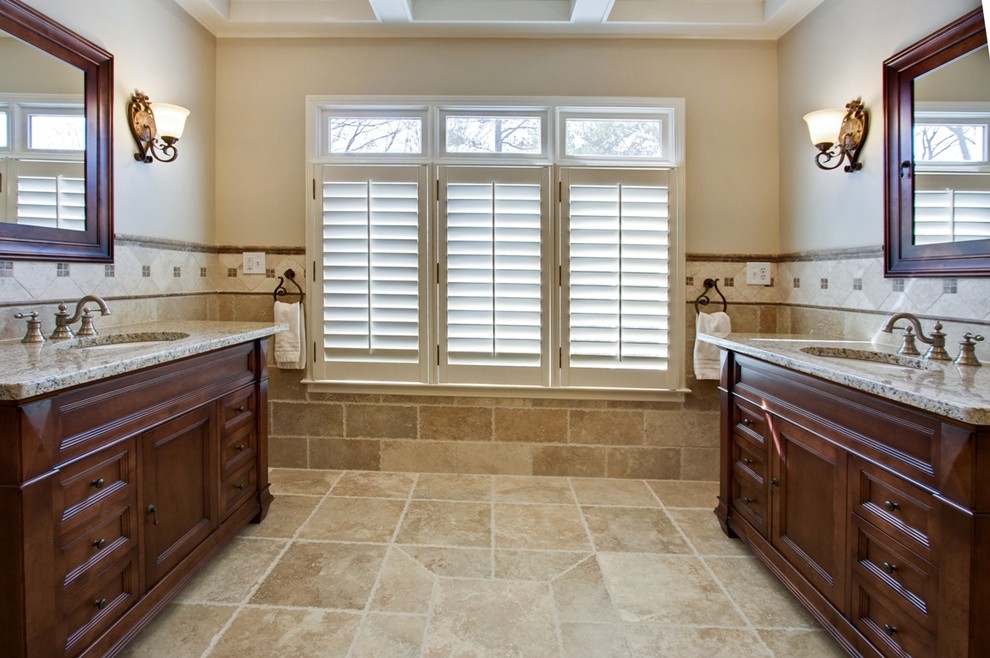 Foto di una stanza da bagno classica con lavabo sottopiano, ante con riquadro incassato, ante in legno bruno e piastrelle beige