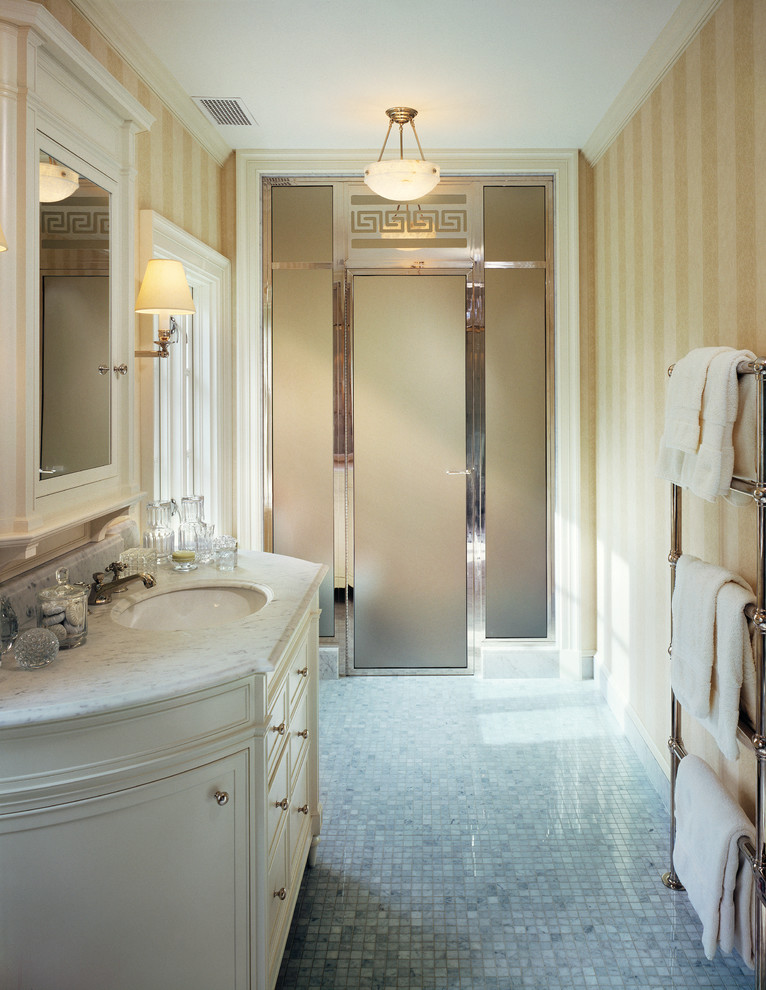 Свежая идея для дизайна: ванная комната среднего размера в классическом стиле с фасадами с выступающей филенкой, белыми фасадами, душем в нише, желтыми стенами, полом из мозаичной плитки, душевой кабиной, врезной раковиной, мраморной столешницей, разноцветным полом и душем с распашными дверями - отличное фото интерьера
