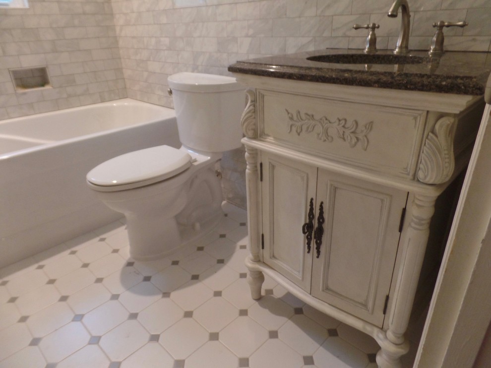 Idee per una stanza da bagno per bambini tradizionale di medie dimensioni con consolle stile comò, ante con finitura invecchiata, vasca ad alcova, vasca/doccia, WC a due pezzi, piastrelle grigie, piastrelle in gres porcellanato, pareti verdi, pavimento con piastrelle in ceramica, lavabo sottopiano e top in granito