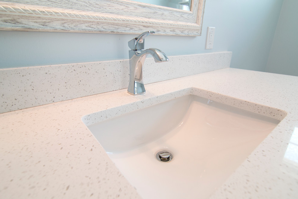 Medium sized nautical ensuite bathroom in New York with shaker cabinets, white cabinets, a walk-in shower, grey tiles, pebble tiles, blue walls, ceramic flooring, a submerged sink and engineered stone worktops.