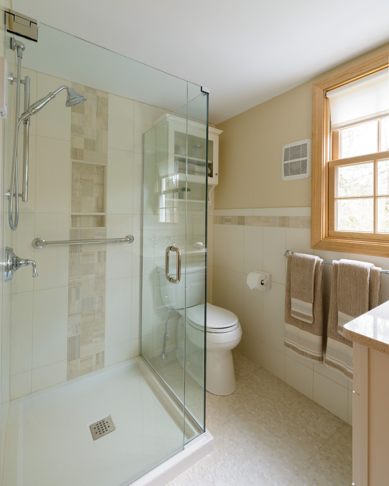 Inspiration for a mid-sized transitional 3/4 beige tile and porcelain tile porcelain tile and beige floor corner shower remodel in Boston with white cabinets, a two-piece toilet, an undermount sink, quartz countertops, beige walls and a hinged shower door