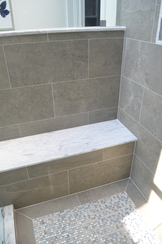 Aménagement d'une salle de bain principale classique de taille moyenne avec un placard avec porte à panneau encastré, des portes de placard grises, une douche d'angle, un carrelage beige, un carrelage gris, un carrelage blanc, mosaïque, un mur gris, un sol en carrelage de céramique, un lavabo encastré et un plan de toilette en marbre.