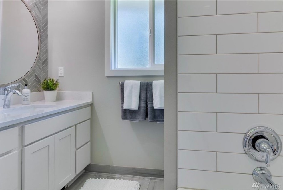 Design ideas for a classic ensuite bathroom in Seattle with shaker cabinets, white cabinets, an alcove bath, a shower/bath combination, a two-piece toilet, grey tiles, ceramic tiles, grey walls, ceramic flooring, a submerged sink, engineered stone worktops, grey floors and a shower curtain.