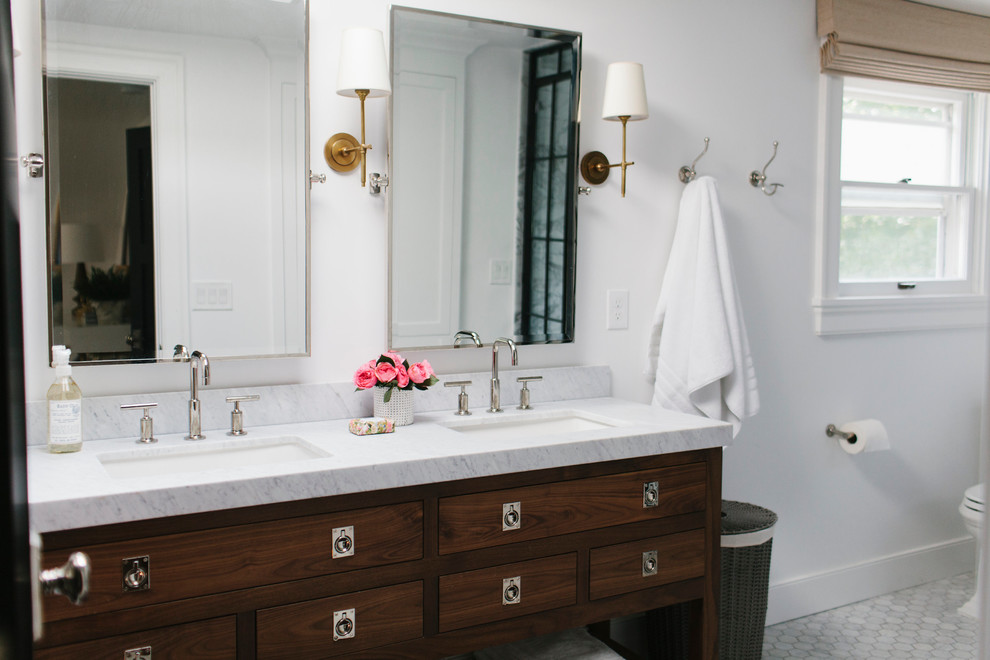 Inspiration for a master bathroom remodel in Salt Lake City with a drop-in sink, furniture-like cabinets, dark wood cabinets, marble countertops and white walls