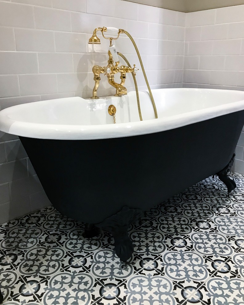 Réalisation d'une salle de bain de taille moyenne avec une baignoire indépendante, un carrelage blanc, carreaux de ciment au sol et un sol noir.