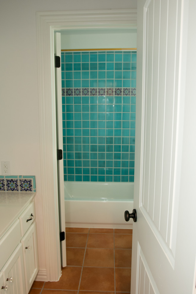 Свежая идея для дизайна: ванная комната среднего размера в средиземноморском стиле с фасадами с утопленной филенкой, белыми фасадами, ванной в нише, душем над ванной, синей плиткой, разноцветной плиткой, керамической плиткой, полом из терракотовой плитки, душевой кабиной, коричневым полом, шторкой для ванной и белой столешницей - отличное фото интерьера