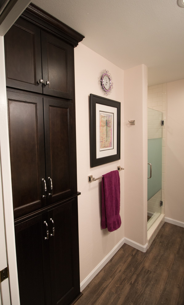 Réalisation d'une salle de bain principale tradition en bois foncé de taille moyenne avec un placard à porte plane, WC séparés, un carrelage blanc, un carrelage métro, un mur rose, un lavabo encastré, un plan de toilette en quartz modifié et un sol marron.