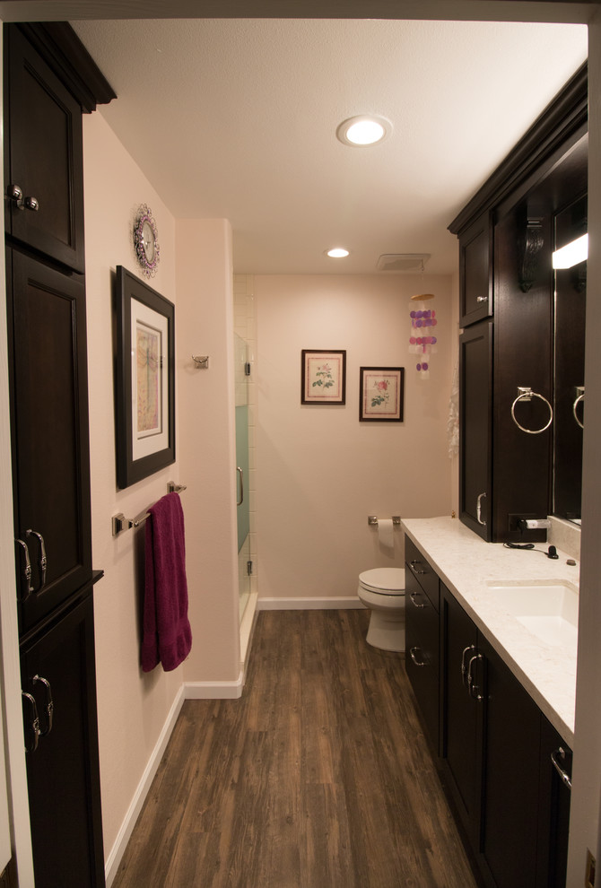 Пример оригинального дизайна: главная ванная комната среднего размера в стиле неоклассика (современная классика) с плоскими фасадами, темными деревянными фасадами, раздельным унитазом, белой плиткой, плиткой кабанчик, розовыми стенами, врезной раковиной, столешницей из искусственного кварца и коричневым полом