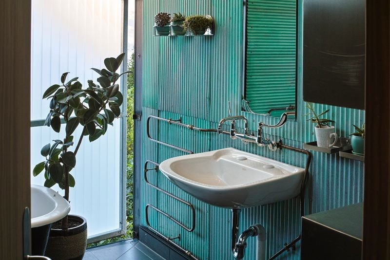 Modelo de cuarto de baño principal bohemio de tamaño medio con bañera con patas, baldosas y/o azulejos de metal, paredes verdes, suelo de baldosas de cerámica, lavabo encastrado y suelo negro
