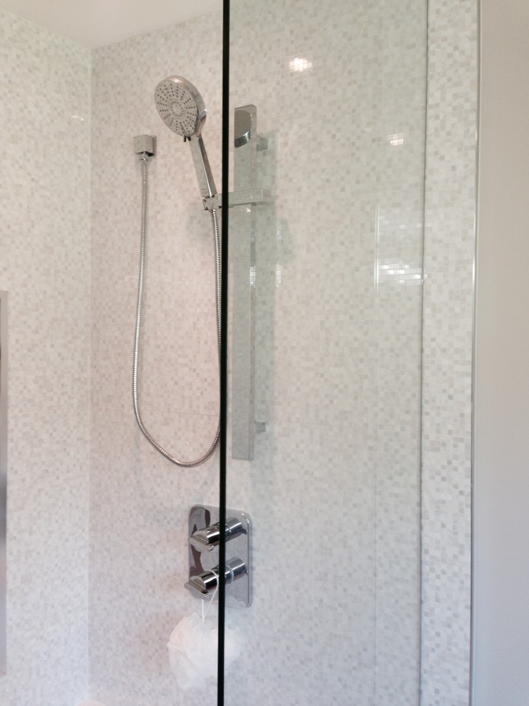 Immagine di una stanza da bagno tradizionale con lavabo da incasso, ante bianche, top in superficie solida, piastrelle bianche e pareti grigie