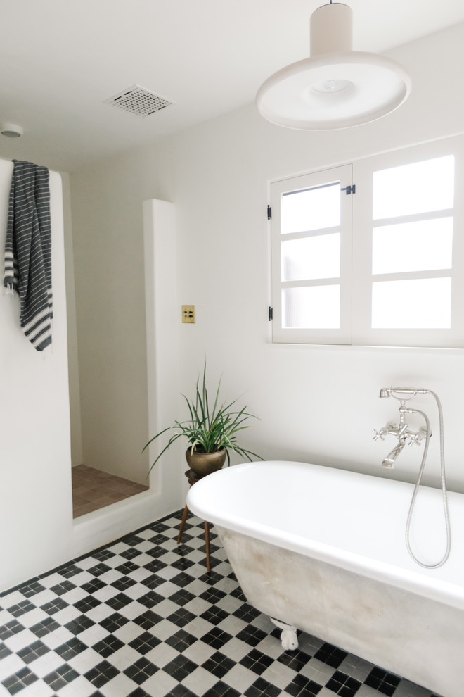 Amerikansk inredning av ett stort vit vitt en-suite badrum, med släta luckor, vita skåp, ett badkar med tassar, en hörndusch, vita väggar, klinkergolv i porslin, ett piedestal handfat, bänkskiva i akrylsten, flerfärgat golv och med dusch som är öppen