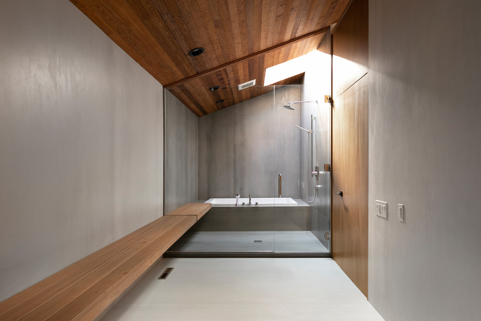 Inredning av ett modernt badrum, med ett platsbyggt badkar, våtrum, grå väggar, vitt golv och dusch med gångjärnsdörr