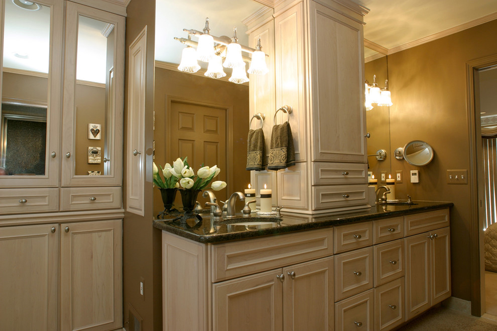Immagine di una stanza da bagno classica con lavabo sottopiano, ante con riquadro incassato e ante in legno chiaro