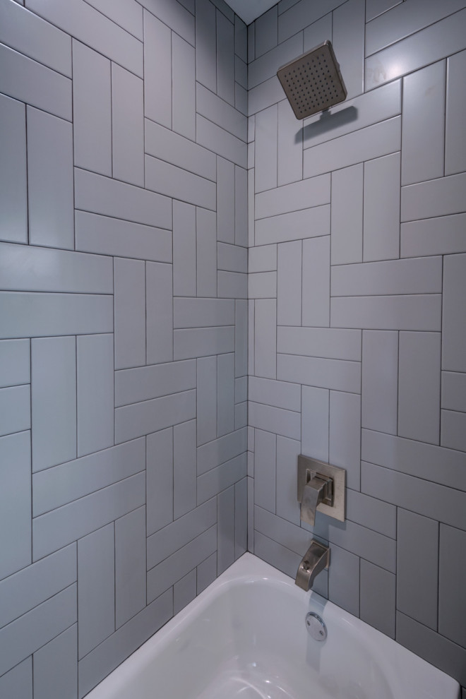 Réalisation d'une salle de bain principale de taille moyenne avec un placard avec porte à panneau encastré, des portes de placard bleues, une baignoire en alcôve, un combiné douche/baignoire, WC séparés, un carrelage gris, des carreaux de céramique, un mur blanc, carreaux de ciment au sol, un lavabo encastré, un plan de toilette en marbre, un sol gris, une cabine de douche avec un rideau, un plan de toilette multicolore, meuble double vasque et meuble-lavabo encastré.