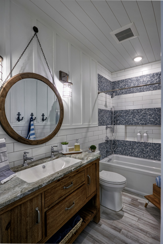 Стильный дизайн: детская ванная комната среднего размера в морском стиле с фасадами островного типа, искусственно-состаренными фасадами, ванной в нише, душем над ванной, унитазом-моноблоком, белой плиткой, цементной плиткой, белыми стенами, полом из цементной плитки, врезной раковиной, столешницей из гранита, разноцветным полом, шторкой для ванной, разноцветной столешницей, тумбой под одну раковину, напольной тумбой, потолком из вагонки и панелями на стенах - последний тренд