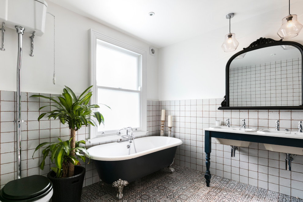 Elegant mosaic tile floor claw-foot bathtub photo in London with white walls and a console sink