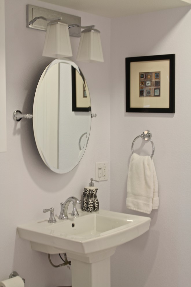 Modelo de cuarto de baño actual de tamaño medio con sanitario de dos piezas, paredes beige, suelo de linóleo, aseo y ducha y lavabo con pedestal