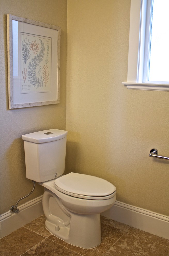 Cette photo montre un WC et toilettes tendance de taille moyenne avec WC séparés, un mur beige, tomettes au sol, un lavabo de ferme, un placard à porte plane, des portes de placard noires, un carrelage beige et des carreaux en allumettes.