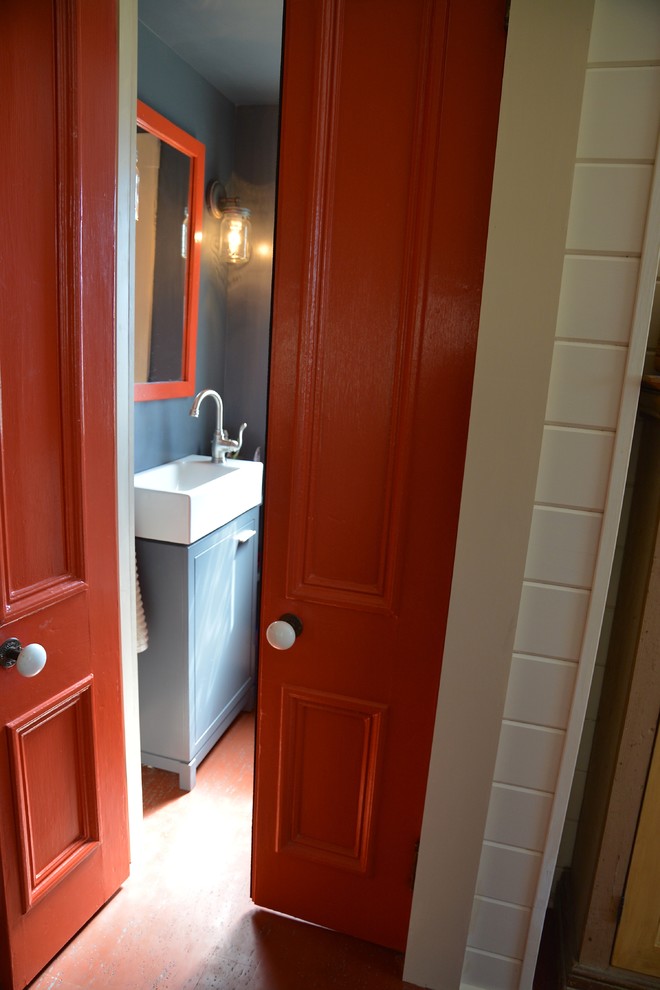 Foto di una stanza da bagno con doccia design di medie dimensioni con ante lisce, ante grigie, WC monopezzo, pareti grigie, pavimento in cemento, lavabo rettangolare e top in superficie solida