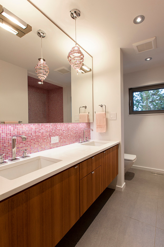 エドモントンにあるコンテンポラリースタイルのおしゃれな浴室 (アンダーカウンター洗面器、フラットパネル扉のキャビネット、中間色木目調キャビネット、ピンクのタイル、モザイクタイル) の写真