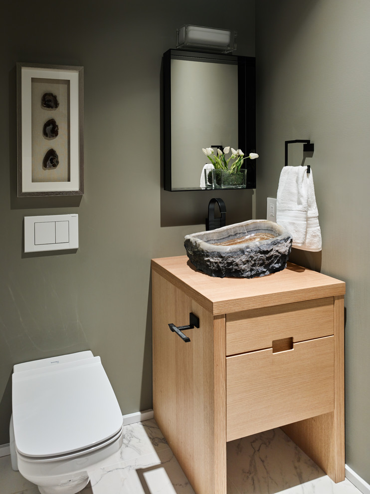 Exempel på ett litet modernt toalett, med möbel-liknande, skåp i mellenmörkt trä, en vägghängd toalettstol, vit kakel, porslinskakel, gröna väggar, klinkergolv i porslin, ett fristående handfat och träbänkskiva