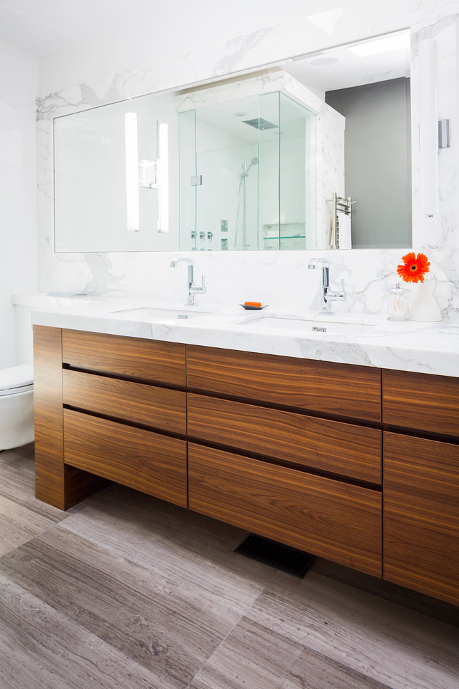 Modelo de cuarto de baño contemporáneo con armarios con paneles lisos, puertas de armario de madera oscura, encimera de mármol, baldosas y/o azulejos blancos y losas de piedra