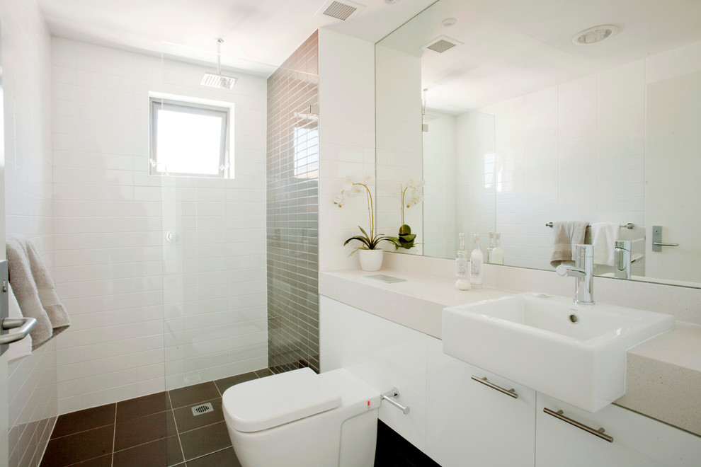 Пример оригинального дизайна: ванная комната среднего размера в стиле модернизм с инсталляцией, белой плиткой, белыми стенами, ванной в нише, душем над ванной, душевой кабиной, раковиной с несколькими смесителями, коричневым полом и открытым душем