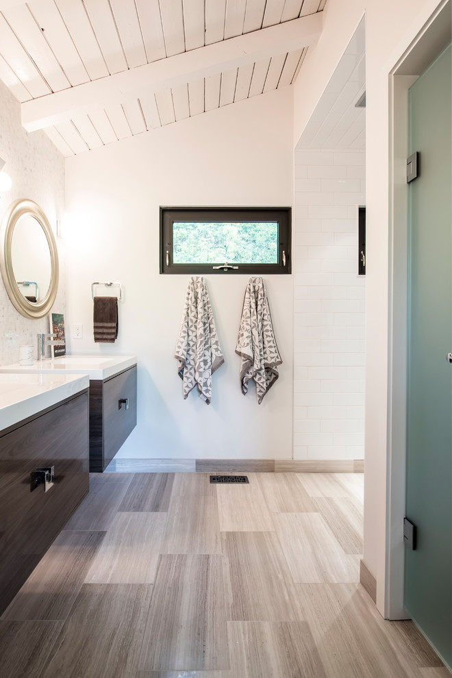 Cette photo montre une grande salle de bain principale moderne en bois brun avec un placard à porte plane, WC séparés, un carrelage noir et blanc, un carrelage de pierre, un mur blanc, un sol en calcaire et un plan de toilette en quartz modifié.