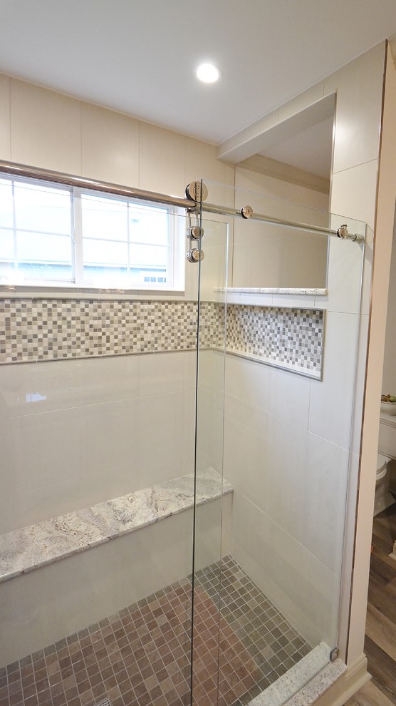 Klassisk inredning av ett mellanstort en-suite badrum, med luckor med upphöjd panel, vita skåp, ett undermonterat badkar, en dusch i en alkov, en toalettstol med hel cisternkåpa, beige väggar, ljust trägolv, ett undermonterad handfat och granitbänkskiva