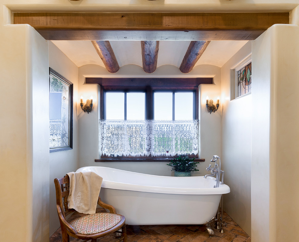 Ispirazione per una stanza da bagno stile americano con vasca con piedi a zampa di leone, pareti beige e pavimento marrone