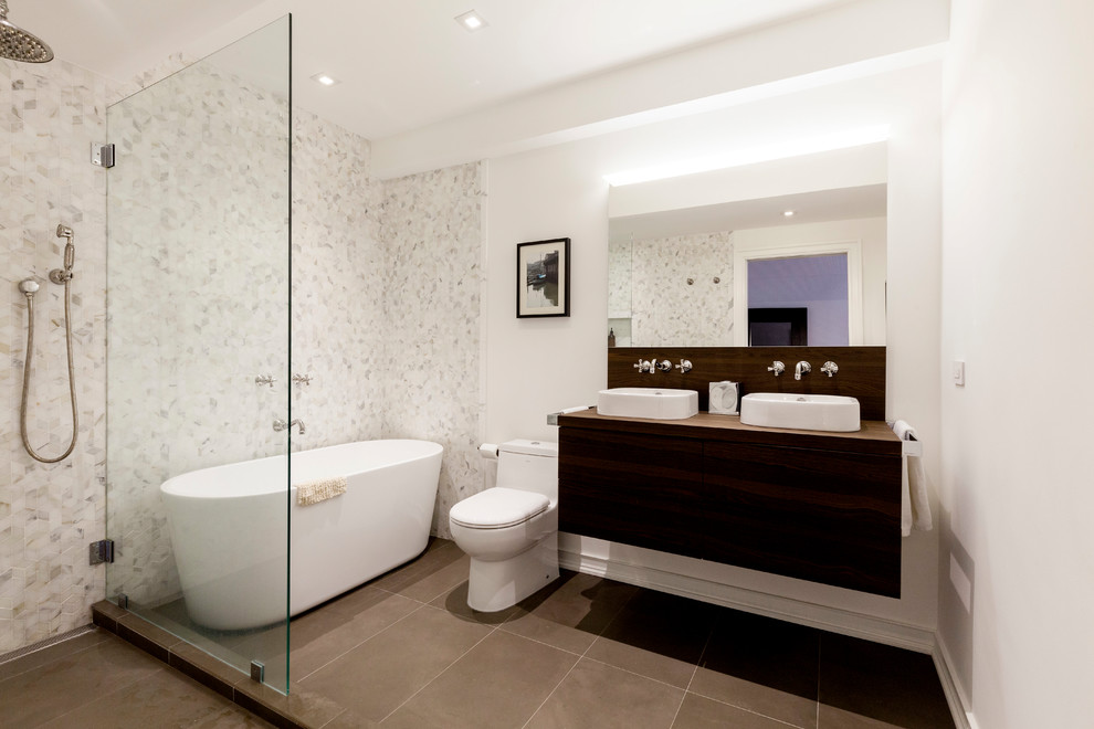 Bathroom - mid-sized contemporary master white tile and marble tile porcelain tile and gray floor bathroom idea in New York with flat-panel cabinets, dark wood cabinets, a one-piece toilet, white walls, a vessel sink, wood countertops and brown countertops