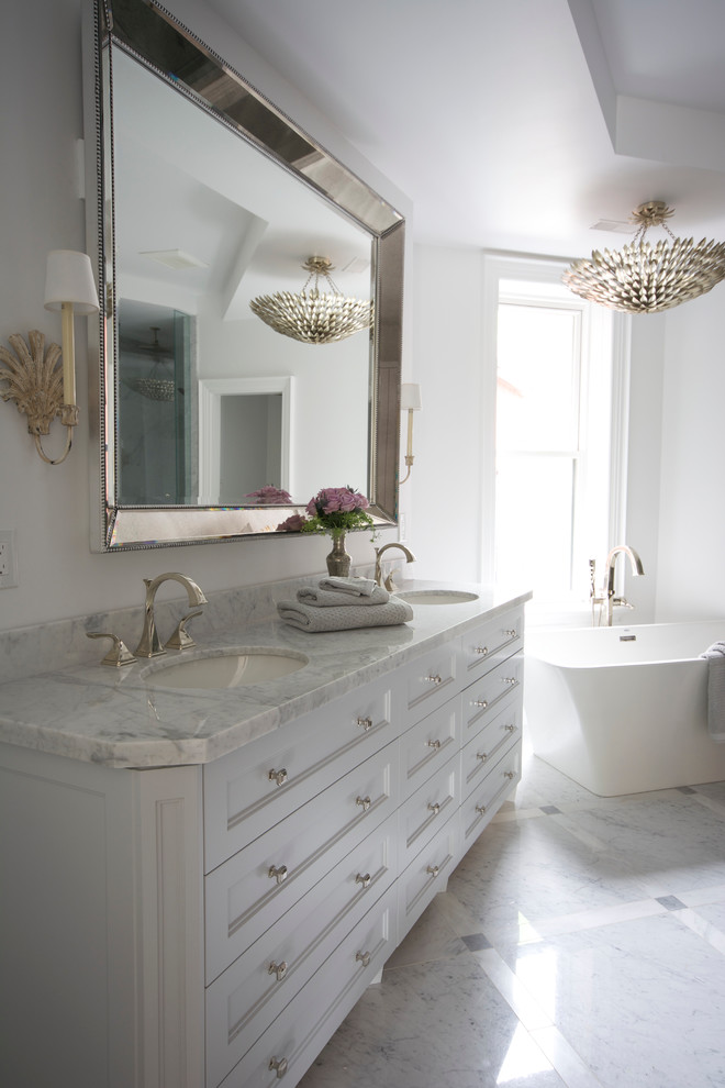 Photo of a large classic ensuite bathroom in Toronto with a submerged sink, recessed-panel cabinets, grey cabinets, marble worktops, a freestanding bath, a corner shower, a one-piece toilet, grey tiles, stone tiles, white walls and marble flooring.