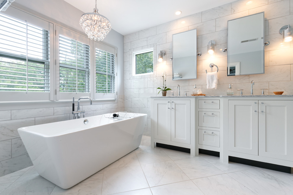 Design ideas for a medium sized traditional ensuite bathroom in Cincinnati with recessed-panel cabinets, white cabinets, a freestanding bath, white tiles, marble flooring, a submerged sink, quartz worktops, a corner shower, marble tiles, white walls, white floors and a hinged door.