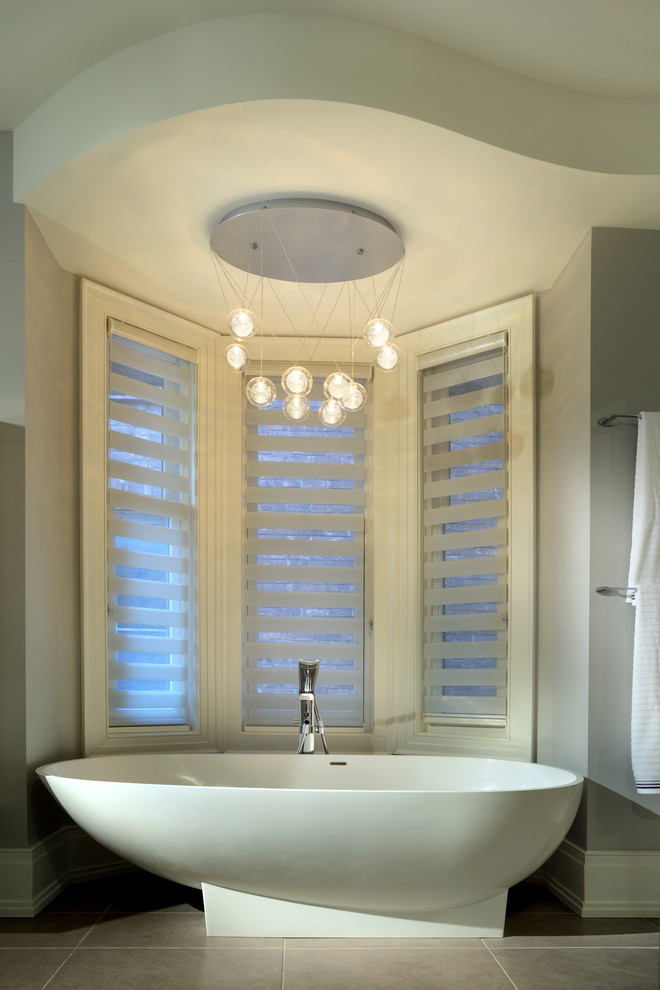 Diseño de cuarto de baño principal actual de tamaño medio con bañera exenta y suelo de baldosas de porcelana