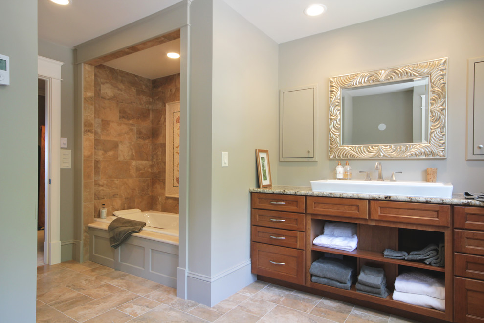 Inspiration pour une grande douche en alcôve traditionnelle en bois brun avec un placard à porte shaker, un plan de toilette en granite, une baignoire en alcôve, un carrelage beige, un carrelage de pierre, un mur gris et un sol en carrelage de céramique.