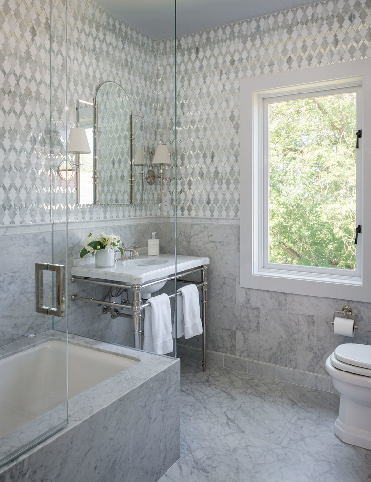 Пример оригинального дизайна: ванная комната в классическом стиле с мраморной столешницей, полновстраиваемой ванной, белой плиткой, плиткой мозаикой, мраморным полом, врезной раковиной и душем над ванной