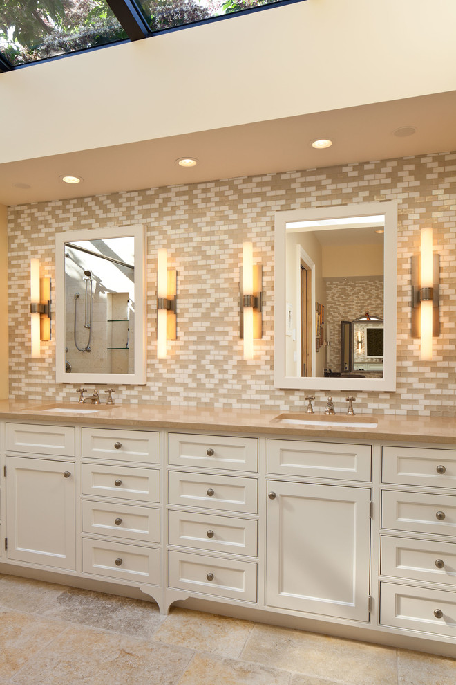 Imagen de cuarto de baño tradicional con baldosas y/o azulejos beige, lavabo bajoencimera, armarios con rebordes decorativos y puertas de armario blancas