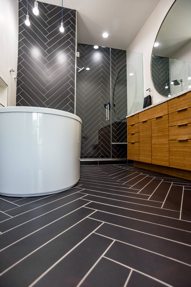 Bathroom - mid-sized modern kids' black tile and ceramic tile ceramic tile and black floor bathroom idea in Other with flat-panel cabinets, light wood cabinets, a one-piece toilet, white walls, a drop-in sink, quartzite countertops, a hinged shower door and white countertops