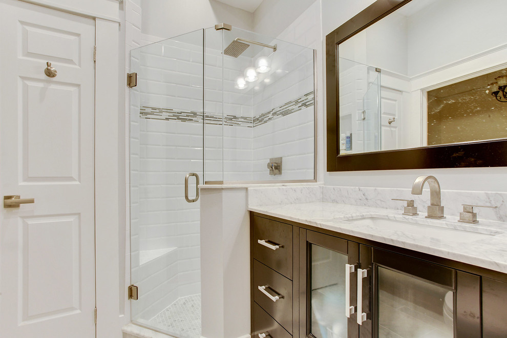 Cette image montre une grande salle de bain principale traditionnelle en bois foncé avec un lavabo encastré, un placard à porte plane, un plan de toilette en marbre, une douche d'angle, un carrelage blanc et un sol en marbre.