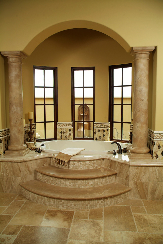 Réalisation d'une grande salle de bain principale méditerranéenne avec un bain bouillonnant, WC à poser, des carreaux de céramique, un mur beige et un sol en carrelage de céramique.