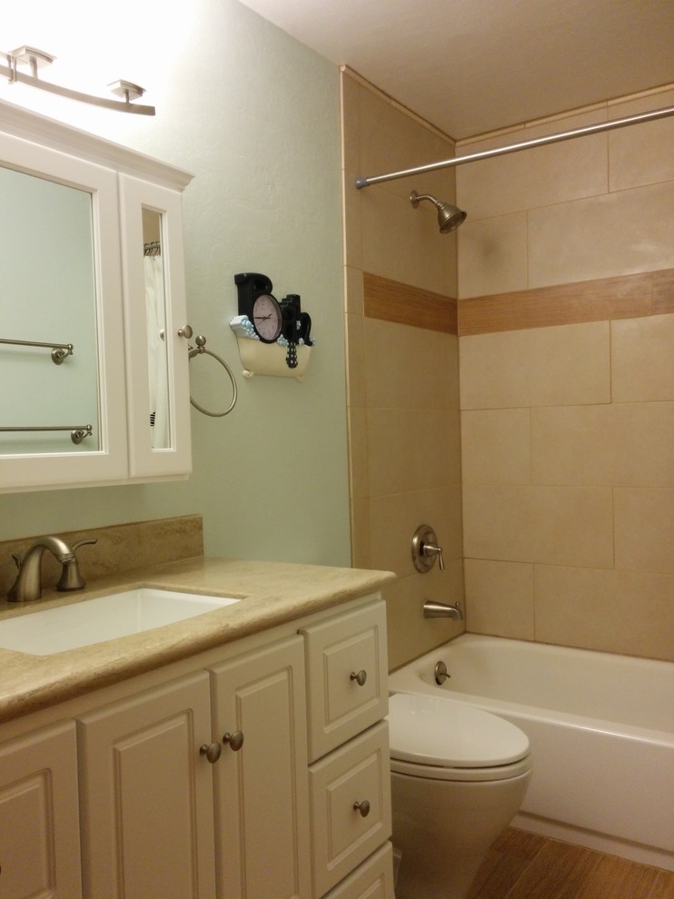 Idéer för ett litet klassiskt en-suite badrum, med ett undermonterad handfat, luckor med upphöjd panel, vita skåp, bänkskiva i akrylsten, ett badkar i en alkov, en dusch/badkar-kombination, en toalettstol med separat cisternkåpa, beige kakel, porslinskakel, gröna väggar och klinkergolv i porslin