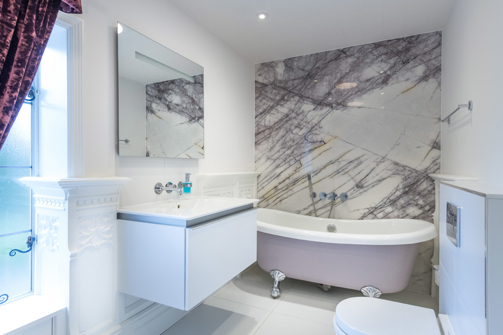 Пример оригинального дизайна: ванная комната в современном стиле с подвесной раковиной, плоскими фасадами, белыми фасадами, ванной на ножках, унитазом-моноблоком, белой плиткой и белыми стенами