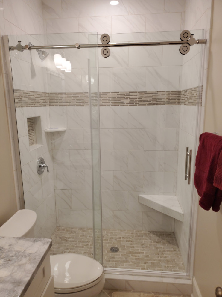 Inredning av ett klassiskt litet badrum, med vita skåp, en dusch i en alkov, en toalettstol med separat cisternkåpa, beige väggar, klinkergolv i porslin, bänkskiva i kvartsit och dusch med skjutdörr