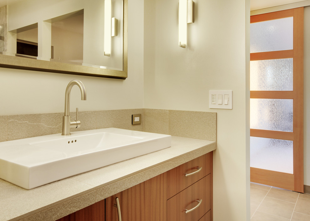 Inspiration for a large modern master gray tile and stone tile pebble tile floor double shower remodel in Seattle with a vessel sink, flat-panel cabinets, medium tone wood cabinets and tile countertops