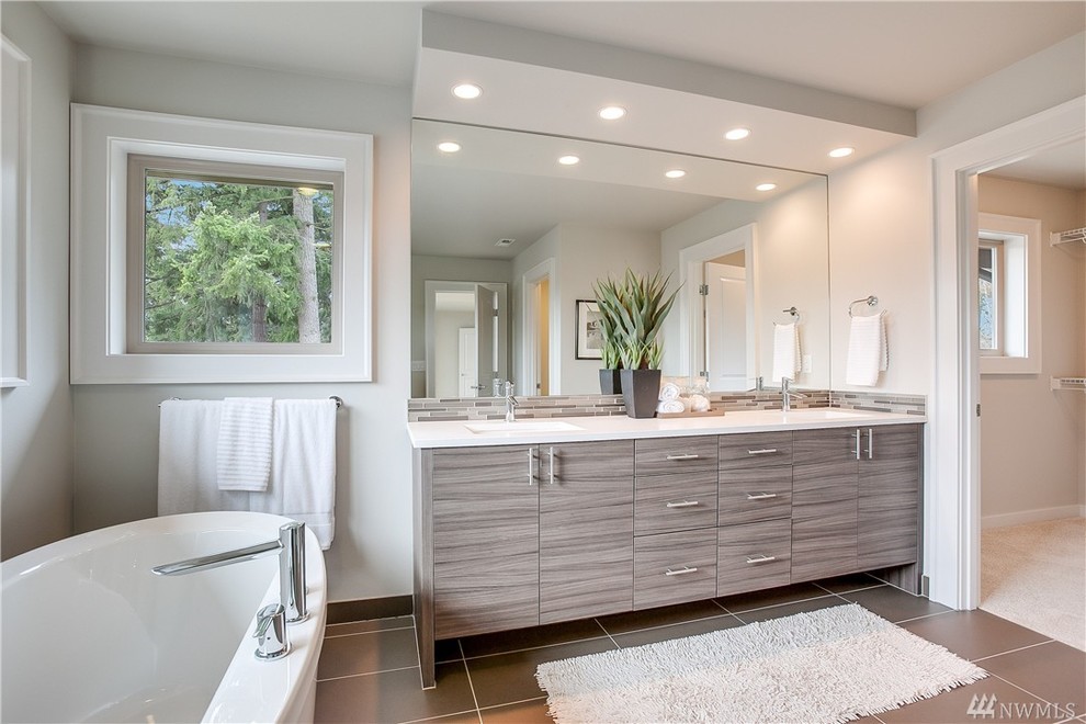 Expansive contemporary ensuite bathroom in Seattle with flat-panel cabinets, a freestanding bath, a corner shower and engineered stone worktops.